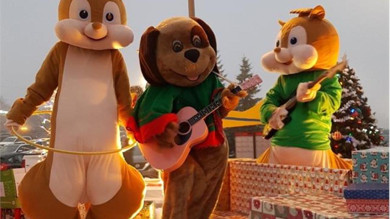 Chipmunk mascots and a dog mascot play guitars among wrapped gifts.