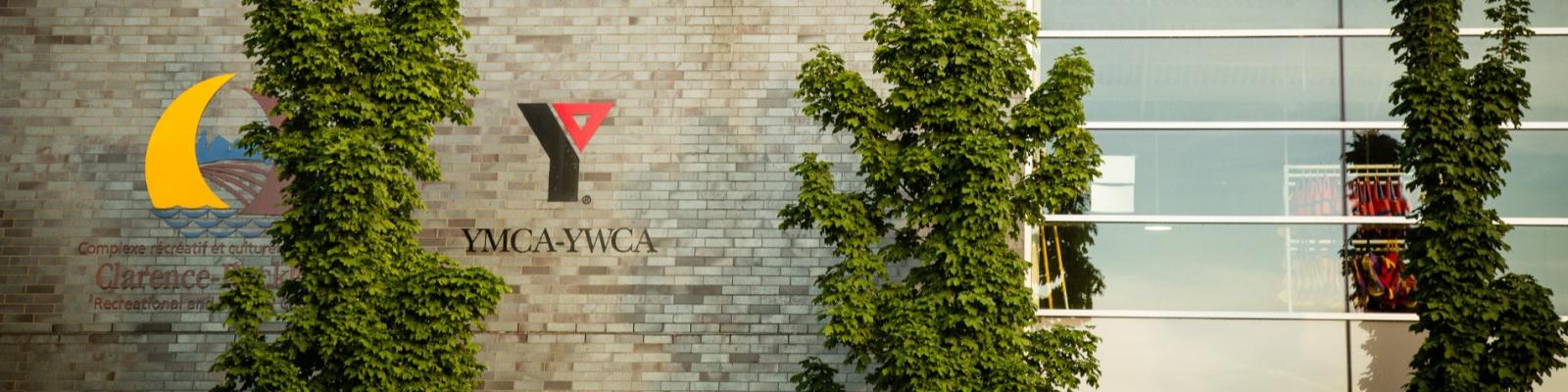 Brick wall with logos and climbing ivy plants.